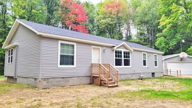 rear view of house with a garage and an outdoor structure