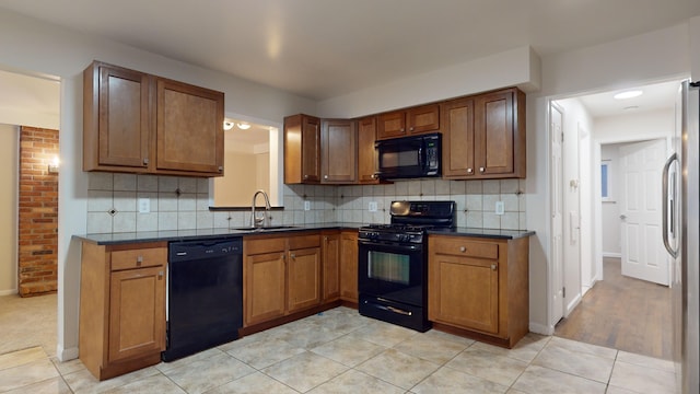 kitchen with black appliances, light tile patterned flooring, and sink