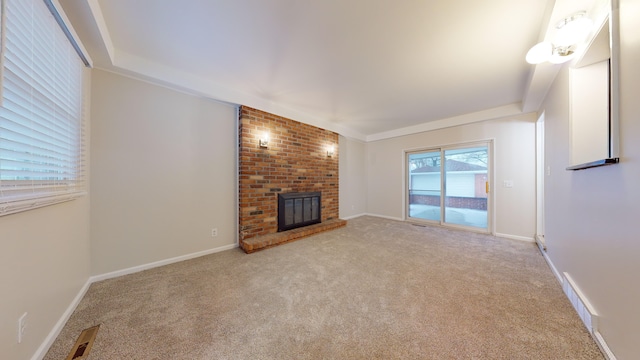 unfurnished living room featuring light colored carpet, a brick fireplace, and crown molding