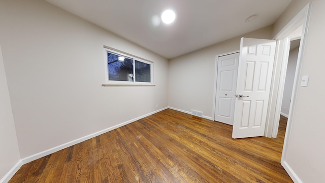 unfurnished bedroom with a closet and dark hardwood / wood-style flooring