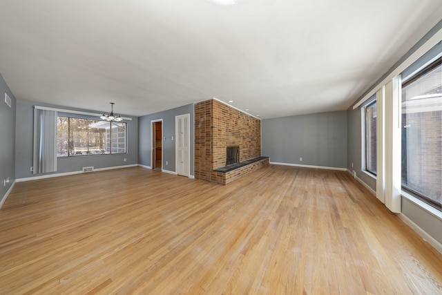 unfurnished living room with a fireplace, ceiling fan, and light hardwood / wood-style flooring