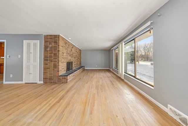 unfurnished living room featuring light wood-type flooring and a fireplace