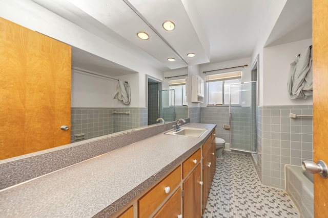 bathroom featuring vanity, an enclosed shower, tile walls, and toilet