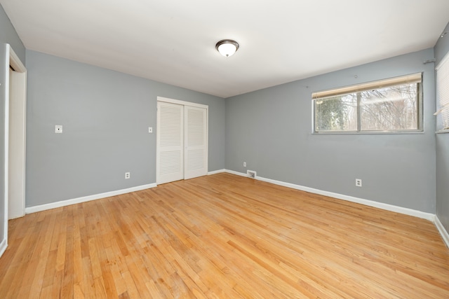 unfurnished bedroom with light hardwood / wood-style floors and a closet