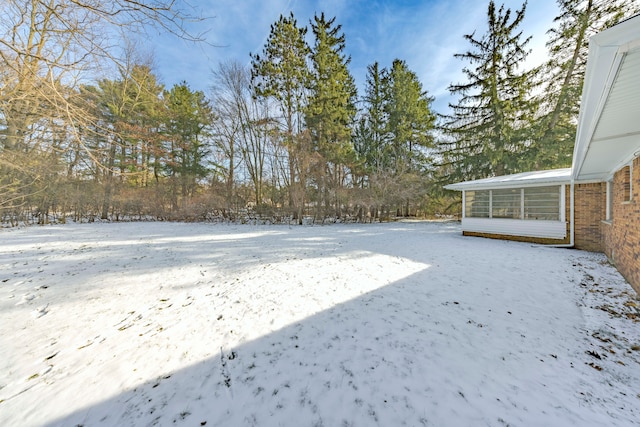 yard layered in snow with a sunroom