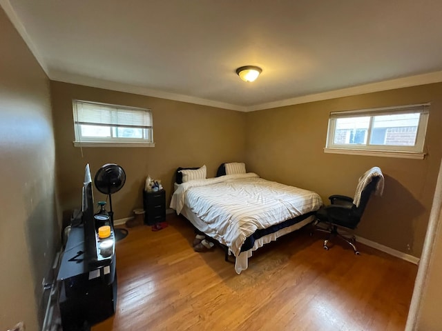 bedroom featuring hardwood / wood-style flooring and crown molding