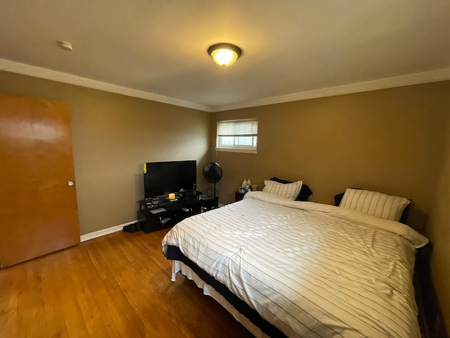 bedroom featuring wood-type flooring and ornamental molding