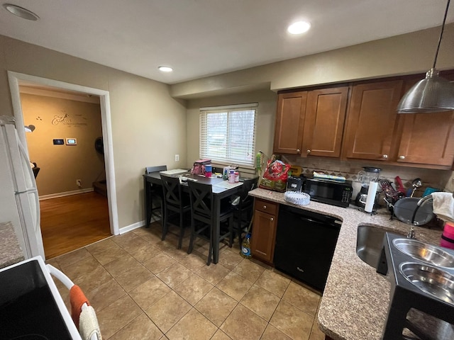 kitchen featuring sink, tasteful backsplash, decorative light fixtures, light tile patterned floors, and black appliances