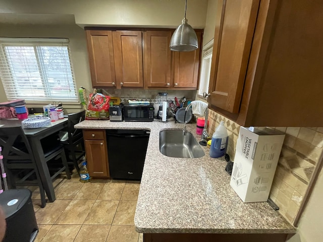 kitchen featuring black appliances, pendant lighting, light stone counters, and backsplash