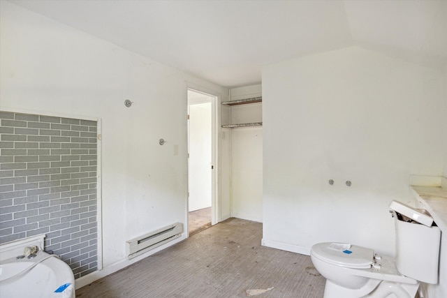 bathroom featuring vaulted ceiling, hardwood / wood-style flooring, toilet, and a baseboard heating unit