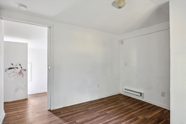 spare room with dark hardwood / wood-style floors and a baseboard radiator