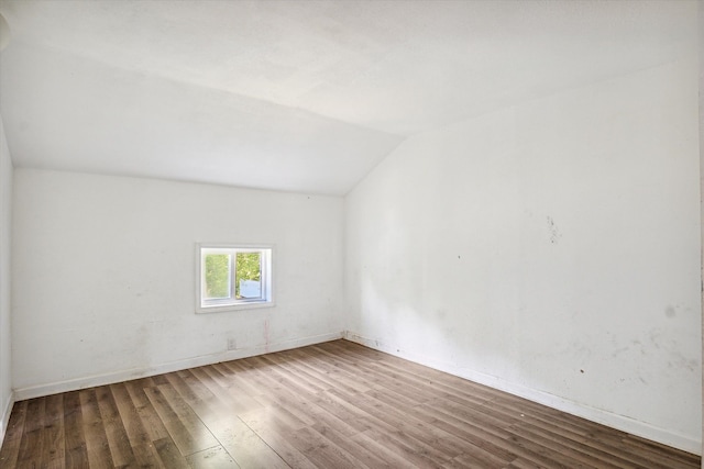 bonus room with hardwood / wood-style floors and vaulted ceiling