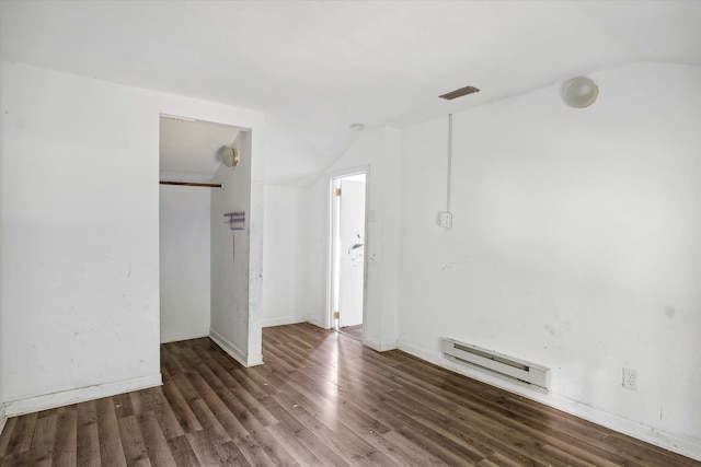 empty room with a baseboard radiator, dark wood-type flooring, and vaulted ceiling