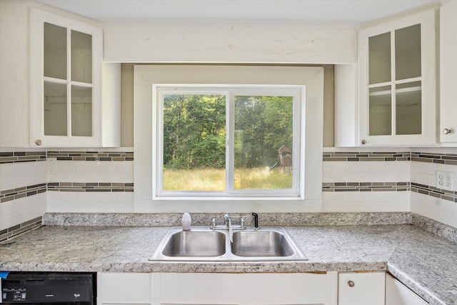 kitchen featuring white cabinets, decorative backsplash, dishwasher, and sink