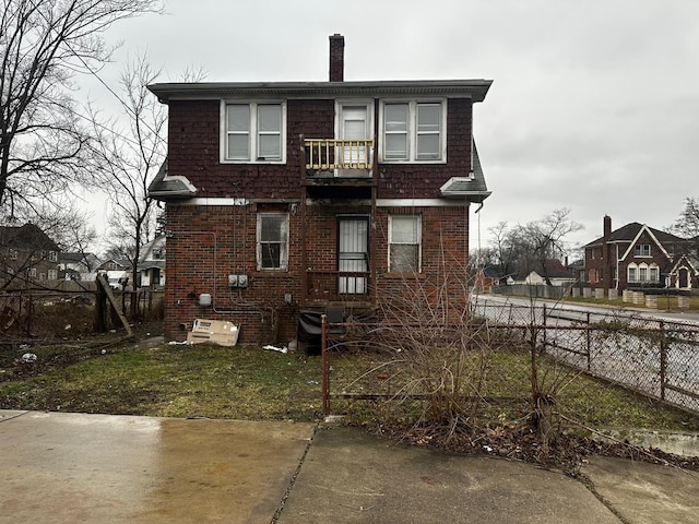 back of property featuring a lawn and a balcony