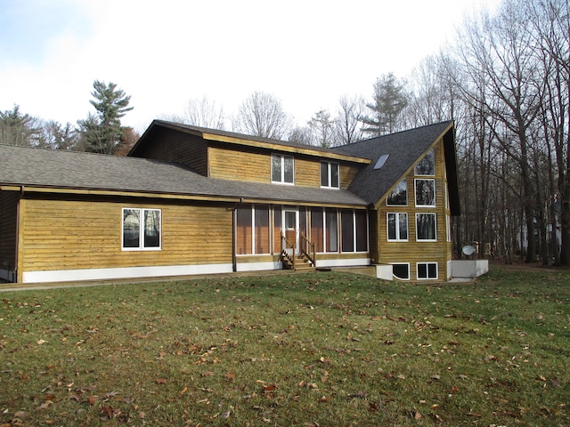 back of property with a lawn and a sunroom