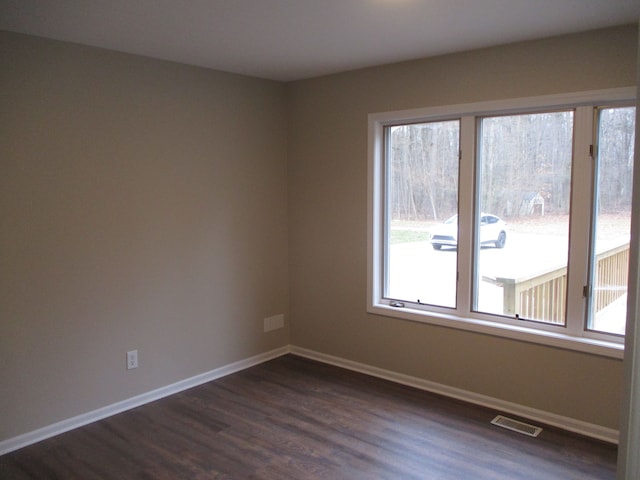 unfurnished room with dark wood-type flooring