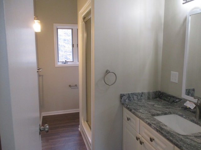 bathroom featuring walk in shower, vanity, and hardwood / wood-style flooring