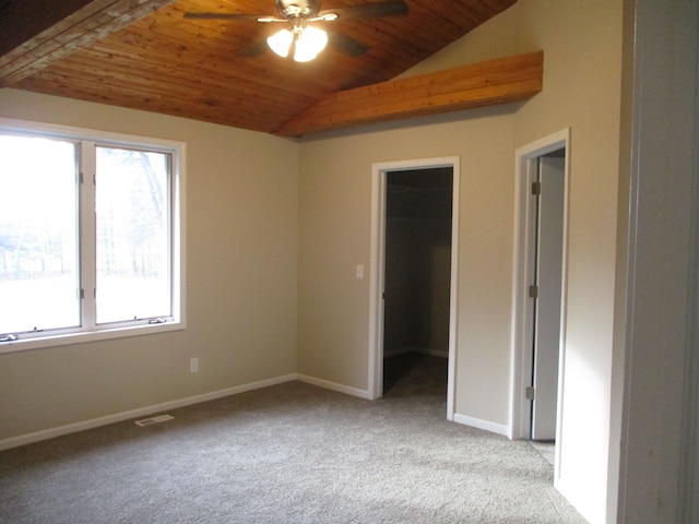 empty room with a healthy amount of sunlight, wooden ceiling, and vaulted ceiling