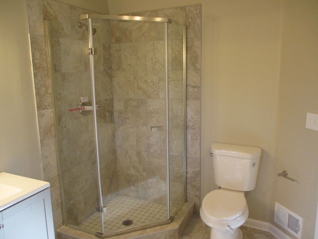 bathroom featuring vanity, toilet, and a shower with shower door