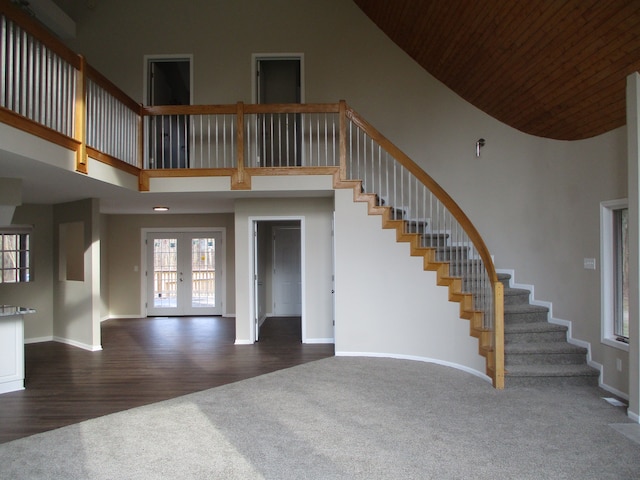 interior space featuring hardwood / wood-style flooring, a towering ceiling, wood ceiling, and french doors