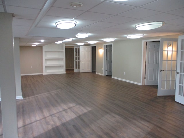 unfurnished living room with french doors, dark hardwood / wood-style floors, and a drop ceiling