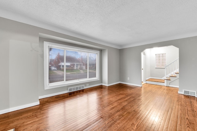 unfurnished living room with hardwood / wood-style floors and a textured ceiling