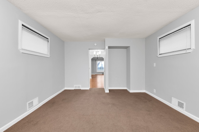 carpeted spare room with a textured ceiling