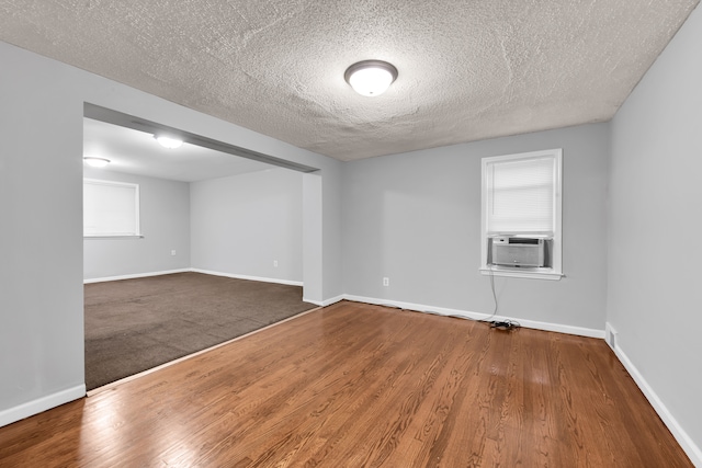 empty room featuring wood-type flooring, a textured ceiling, and plenty of natural light