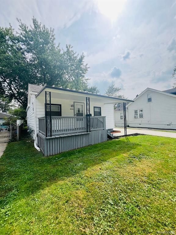 back of property with a porch and a lawn