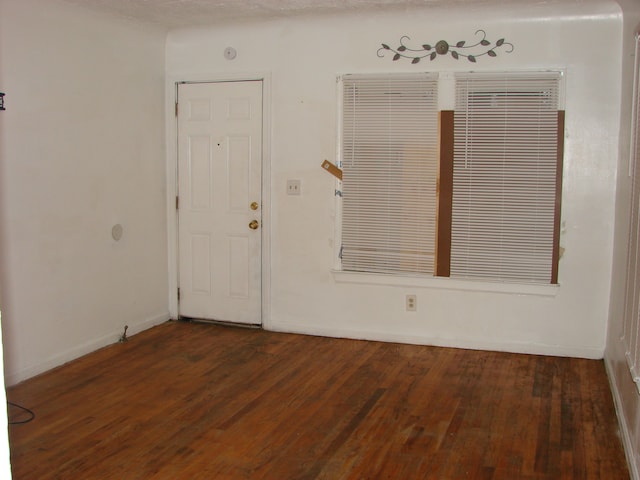 unfurnished room with dark hardwood / wood-style flooring and a textured ceiling