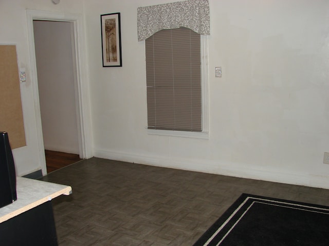 spare room featuring dark parquet floors