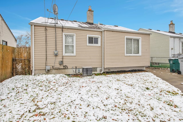 snow covered rear of property featuring cooling unit