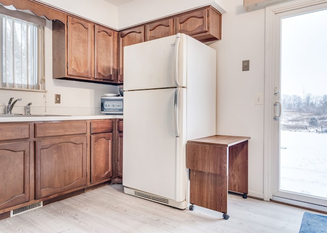 12070 Rattalee Lake Rd, Davisburg, MI 48350 - kitchen featuring freestanding refrigerator, light countertops, brown cabinetry, and light wood finished floors