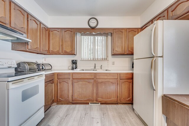 kitchen with white appliances, light hardwood / wood-style floors, and sink