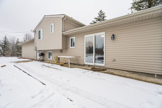 view of snow covered rear of property