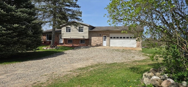 12070 Rattalee Lake Rd, Davisburg, MI 48350 - split level home featuring dirt driveway, brick siding, a garage, and a front yard