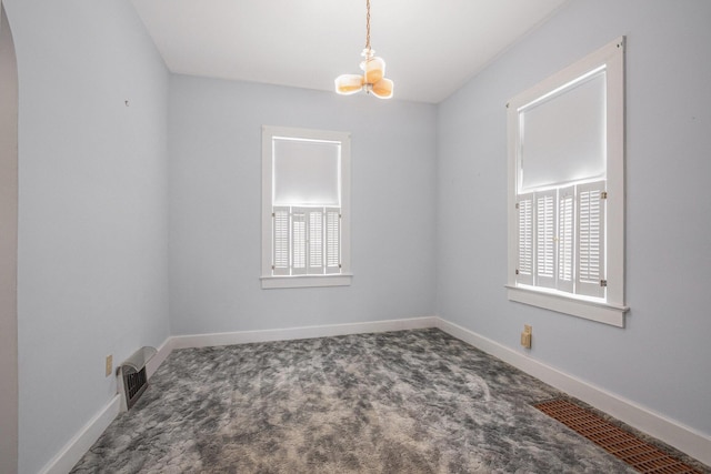 928 Phoenix St, South Haven, MI 49090 - empty room with a chandelier, carpet flooring, baseboards, and arched walkways
