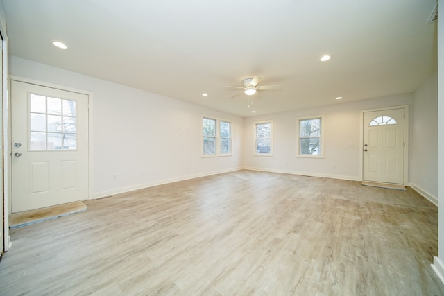 unfurnished living room with light wood-type flooring and ceiling fan