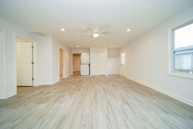 unfurnished room featuring ceiling fan, a wealth of natural light, and light hardwood / wood-style flooring