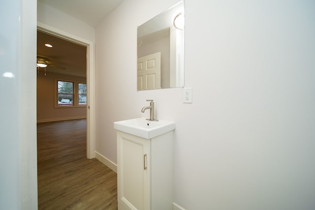 bathroom with hardwood / wood-style floors, vanity, and ceiling fan