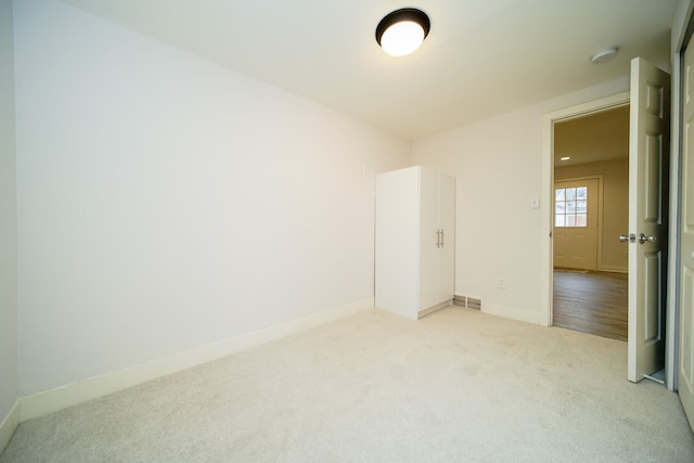 unfurnished room featuring light colored carpet