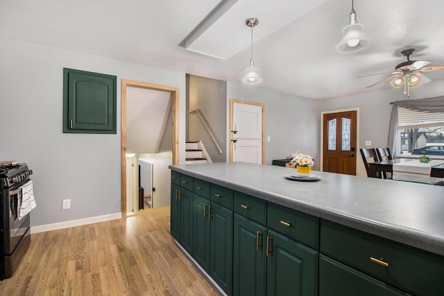 kitchen with hanging light fixtures, light wood-style flooring, black range with gas stovetop, green cabinetry, and baseboards