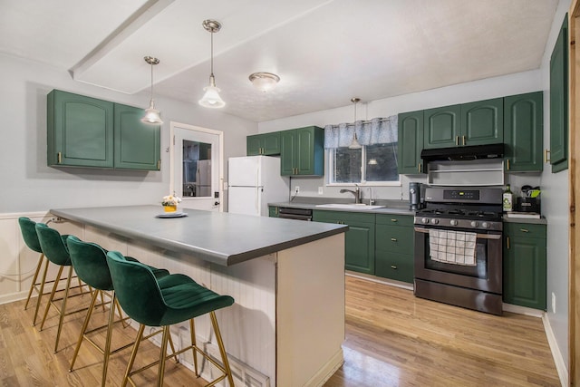 kitchen featuring freestanding refrigerator, a sink, stainless steel gas range oven, and green cabinets