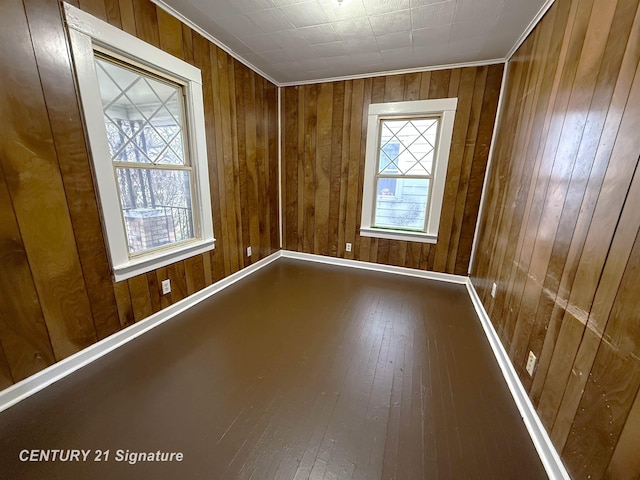 empty room with wood walls and hardwood / wood-style flooring