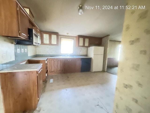 kitchen with backsplash, sink, and white refrigerator