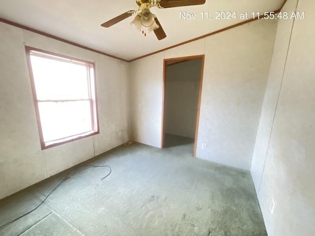 carpeted empty room with crown molding, ceiling fan, and lofted ceiling