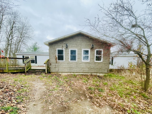 rear view of property featuring a wooden deck