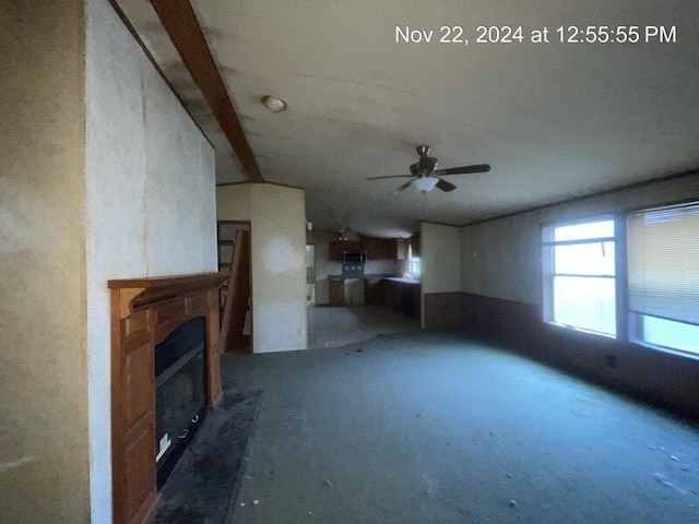 unfurnished living room featuring ceiling fan and concrete flooring