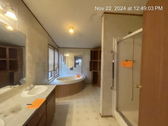 bathroom featuring shower with separate bathtub and vanity